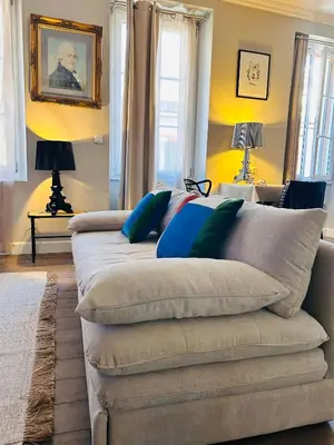 a living room with a couch with blue pillows at Appartement COSY centre Ajaccio in Ajaccio