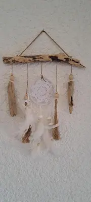 a chandelier made out of drift wood and feathers at Mini villa jardin 50 m plage in Borgo
