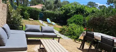 a patio with a couch and a bench and a playground at Mini villa jardin 50 m plage in Borgo