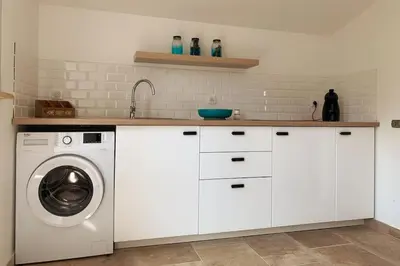 a white kitchen with a washing machine in it at Appartement les pieds dans l'eau in Solaro
