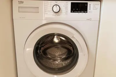 a white washing machine with a clock on it at Appartement les pieds dans l'eau in Solaro
