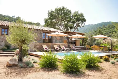 a house with a swimming pool with chairs and umbrellas at Résidence Vista Blu in Conca