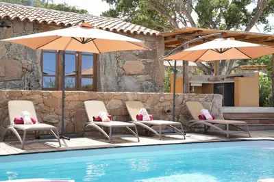 a group of chairs and umbrellas next to a pool at Résidence Vista Blu in Conca