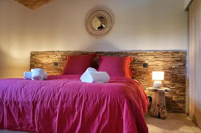 a bedroom with a purple bed with a brick wall at Résidence Vista Blu in Conca