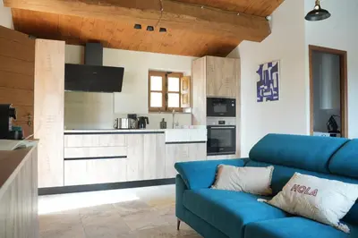 a living room with a blue couch and a kitchen at Résidence Vista Blu in Conca