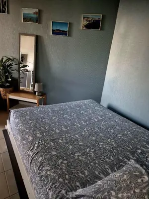 a bed in a bedroom with a blue wall at Chez Céline & Rudi in Moriani Plage