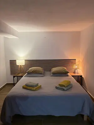 a bedroom with a large bed with two pillows on it at Entre Mer et Montagne in Sartène