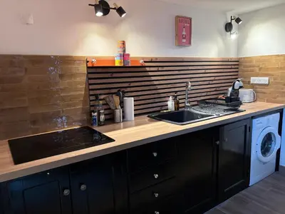 a kitchen with a sink and a washing machine at Entre Mer et Montagne in Sartène