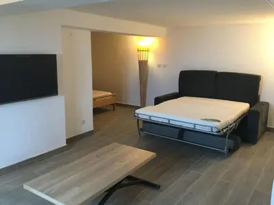 a room with a bed and a couch and a table at Entre Mer et Montagne in Sartène