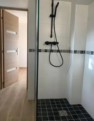 a shower in a bathroom with a glass door at Entre Mer et Montagne in Sartène