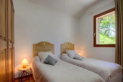 two twin beds in a room with a window at HAUTE CORSE CENTRE CORSE CASTAGNICCIA Gîte de PETRERA 1 CASABIANCA in Casabianca