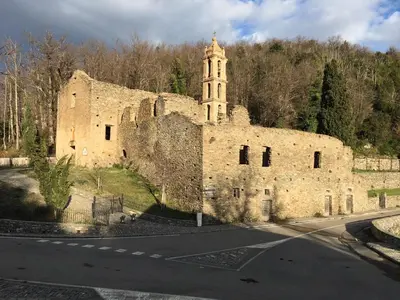 an old stone building with a tower on the side of a road at HAUTE CORSE CENTRE CORSE CASTAGNICCIA Gîte de PETRERA 1 CASABIANCA in Casabianca