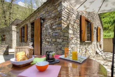 a table in front of a stone house at HAUTE CORSE CENTRE CORSE CASTAGNICCIA Gîte de PETRERA 1 CASABIANCA in Casabianca