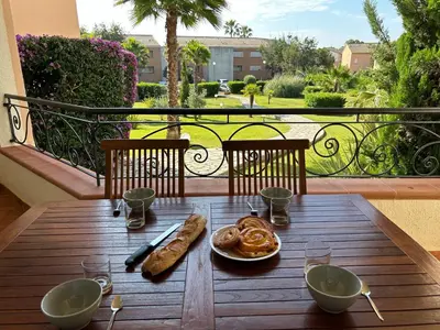 a balcony with a table and chairs and a large window at Appartement, 60m2, 6 couchages avec piscines à Marine de Bravone, Linguizetta, résidence Sognu Di mare Corse in Linguizzetta