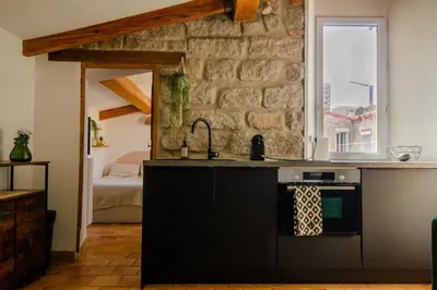 a kitchen with a sink and a stone wall at Charmant T2 au Cœur d'Ajaccio - Parking & AC in Ajaccio