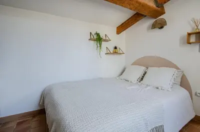 a bedroom with a bed with a white comforter at Charmant T2 au Cœur d'Ajaccio - Parking & AC in Ajaccio