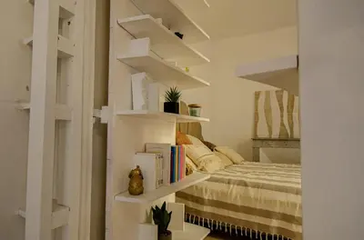 a bedroom with white shelves and a bed with books at Casamea - Apt Spacieux, Clim, Famille & Cabane in Ajaccio