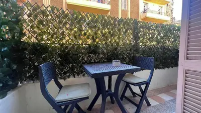 a table and two chairs sitting next to a fence at Casamea - Apt Spacieux, Clim, Famille & Cabane in Ajaccio