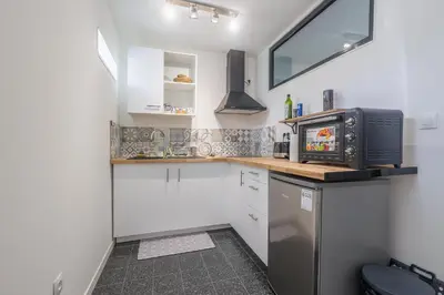 a small kitchen with a microwave and a refrigerator at Terrazza Moriani - Charmant appartement à 500m de la mer in San-Nicolao