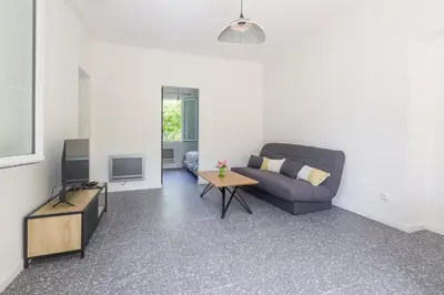 a living room with a couch and a tv at Terrazza Moriani - Charmant appartement à 500m de la mer in San-Nicolao