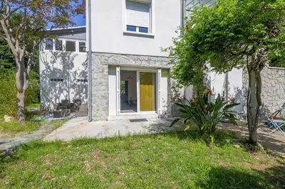 a white house with a yellow door at Terrazza Moriani - Charmant appartement à 500m de la mer in San-Nicolao