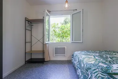 a bedroom with a bed and a window at Terrazza Moriani - Charmant appartement à 500m de la mer in San-Nicolao