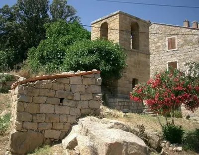 a stone building with a stone wall in front of it at Appartement rénové tout confort 10mn de Campomoro in Grossa