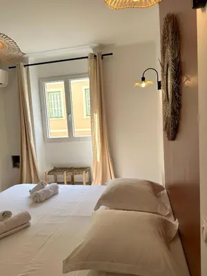a bedroom with a large white bed with a window at Magnifique T3 équipé et climatisé centre Ajaccio idéal 4 personnes in Ajaccio