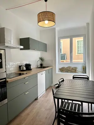 a kitchen with a table and a dining room at Magnifique T3 équipé et climatisé centre Ajaccio idéal 4 personnes in Ajaccio