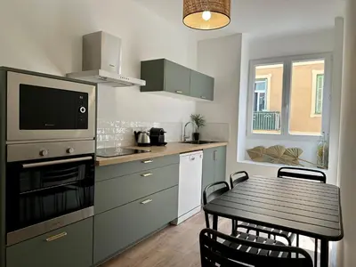 a kitchen with a table and a dining room at Magnifique T3 équipé et climatisé centre Ajaccio idéal 4 personnes in Ajaccio