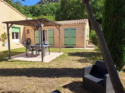 a patio with a table and chairs in a yard at Villa Cutalello coté montagne Calenzana in Calenzana