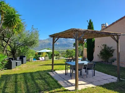 a table and chairs under a pavilion in a yard at Villa Cutalello coté montagne Calenzana in Calenzana