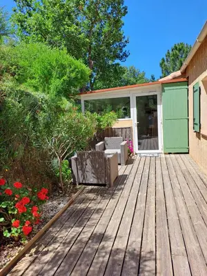 a wooden deck with chairs and flowers in a yard at Villa Cutalello coté montagne Calenzana in Calenzana
