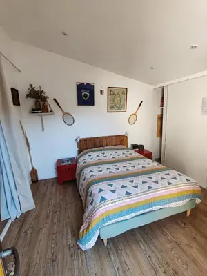 a bedroom with a bed with a wooden floor at Casa Davia. Studio indépendant meublé. in Furiani