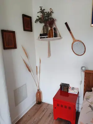 a room with a red table with a shelf on the wall at Casa Davia. Studio indépendant meublé. in Furiani