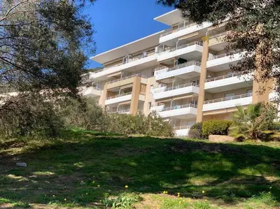 a large apartment building with a yard in front of it at CAPO FENO AJACCIO in Ajaccio