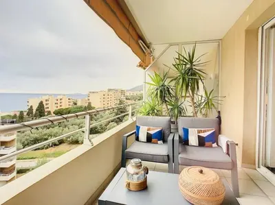 a balcony with two chairs and a table and a window at CAPO FENO AJACCIO in Ajaccio