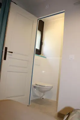 a bathroom with a toilet and a sliding door at Les hauts de Frisella in Monacia-dʼAullène