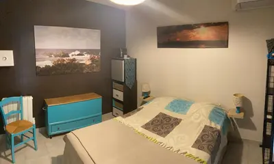 a bedroom with a bed and a dresser and a painting at Les hauts de Frisella in Monacia-dʼAullène
