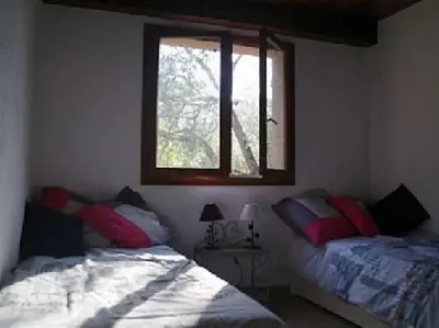a bedroom with two beds and a window at QUIET COTTAGE NEAR CITY CENTER in Porto-Vecchio
