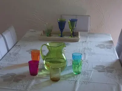 a table with four different colored glasses on it at QUIET COTTAGE NEAR CITY CENTER in Porto-Vecchio