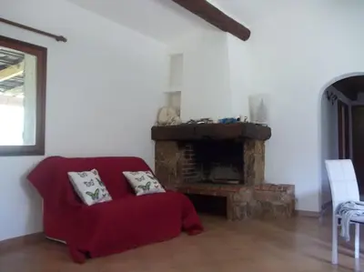 a living room with a red couch and a fireplace at QUIET COTTAGE NEAR CITY CENTER in Porto-Vecchio