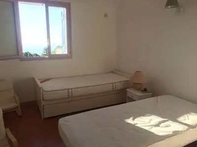 a bedroom with two beds and a window at Fraîcheur et calme en montagne 30 mn de la mer in Porto-Vecchio