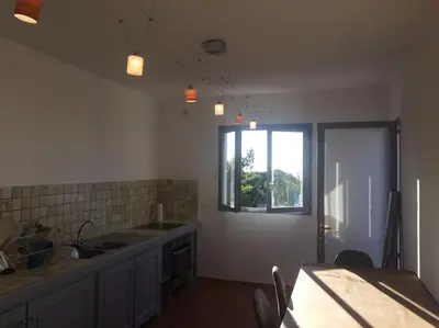 a kitchen with a sink and a table and a window at Fraîcheur et calme en montagne 30 mn de la mer in Porto-Vecchio