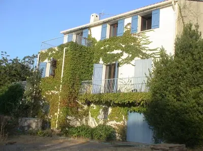 a building with ivy growing on the side of it at Fraîcheur & calme en Montagne, 30minutes de la mer in Porto-Vecchio