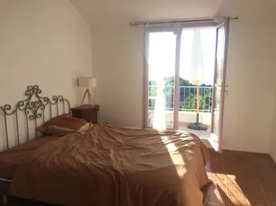a bedroom with a bed and a large window at Fraîcheur & calme en Montagne, 30minutes de la mer in Porto-Vecchio