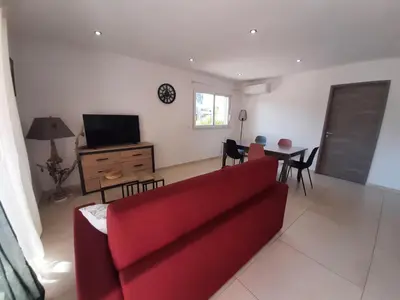 a living room with a red couch and a table at Bel appartement Corse côte Est in Morta