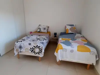 two twin beds in a room with white walls at Bel appartement Corse côte Est in Morta