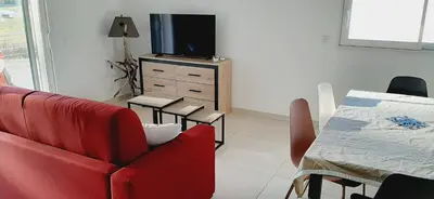 a living room with a red chair and a television at Bel appartement Corse côte Est in Morta