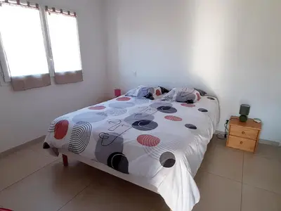a bedroom with a bed with a polka dot blanket at Bel appartement Corse côte Est in Morta
